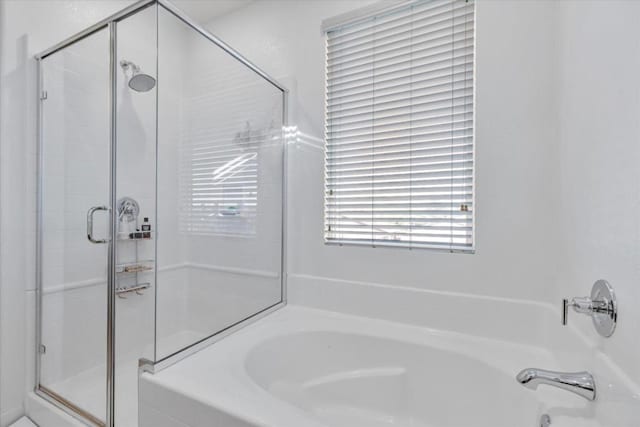 bathroom featuring shower with separate bathtub