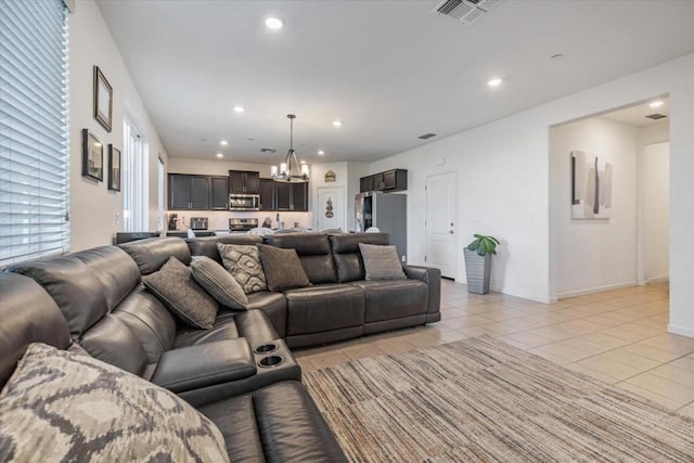 living room featuring light tile patterned flooring and an inviting chandelier