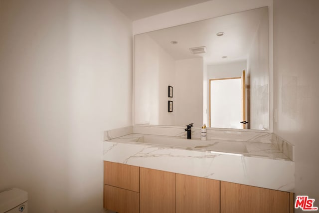 bathroom featuring toilet and vanity