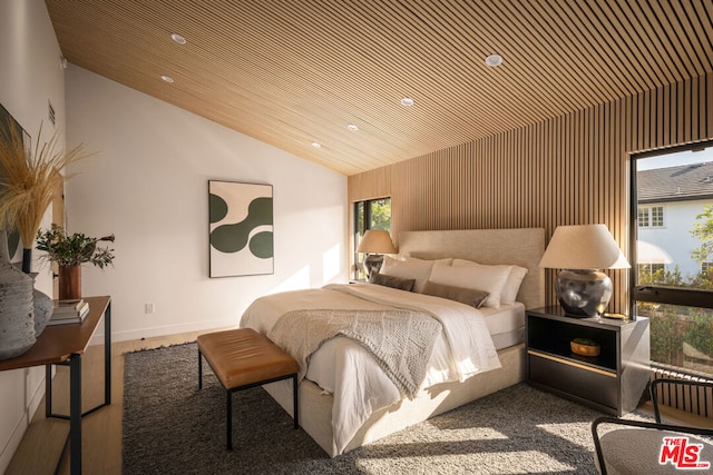 bedroom with vaulted ceiling, wood ceiling, and wood walls