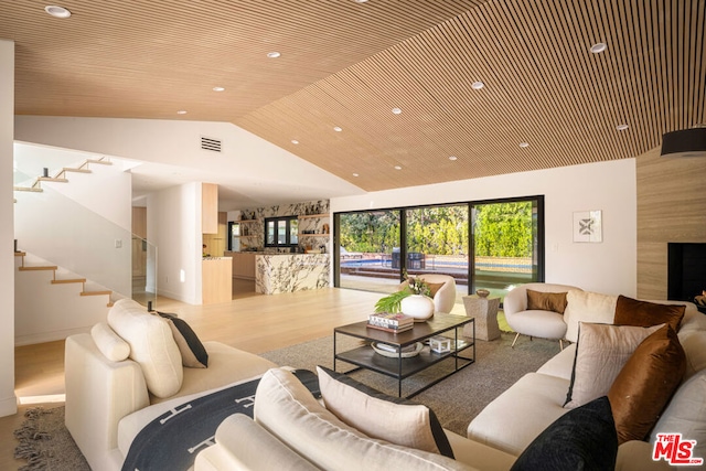 living room with light hardwood / wood-style flooring, vaulted ceiling, and wooden ceiling