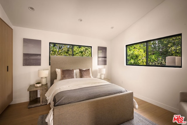 bedroom featuring lofted ceiling and hardwood / wood-style flooring