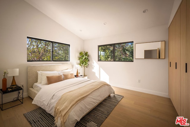 bedroom featuring vaulted ceiling and light hardwood / wood-style flooring