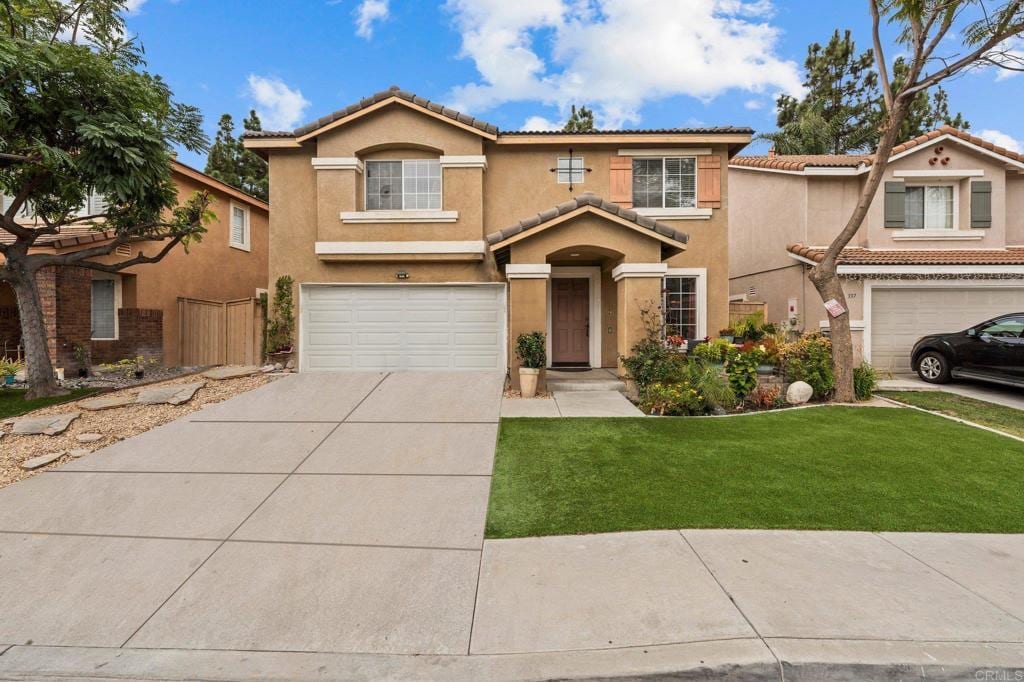 mediterranean / spanish-style home featuring a front yard and a garage