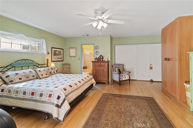 bedroom with ceiling fan, light hardwood / wood-style floors, a closet, and ensuite bath