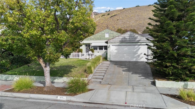 view of front facade with a mountain view, a front lawn, and a garage