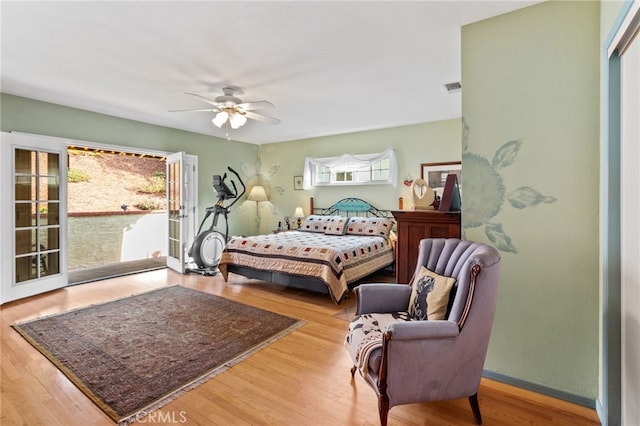 bedroom featuring ceiling fan, multiple windows, hardwood / wood-style flooring, and access to outside