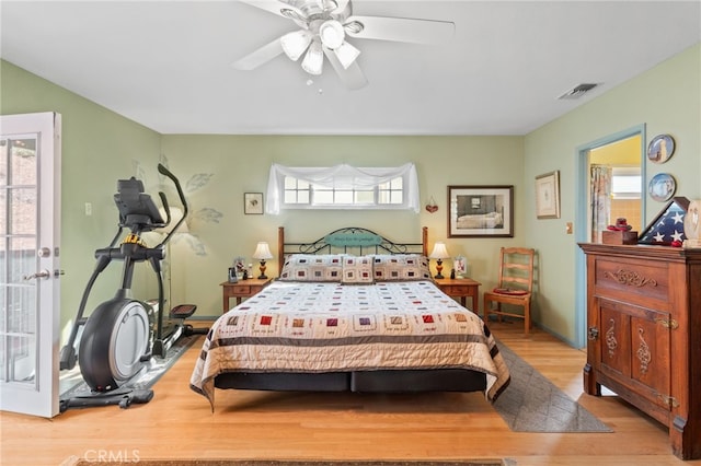 bedroom featuring ceiling fan, light hardwood / wood-style floors, and multiple windows