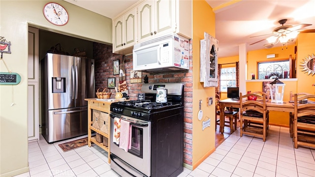 kitchen featuring ceiling fan, white cabinets, appliances with stainless steel finishes, and light tile patterned flooring