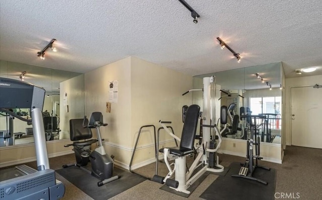 workout area featuring a textured ceiling and baseboards