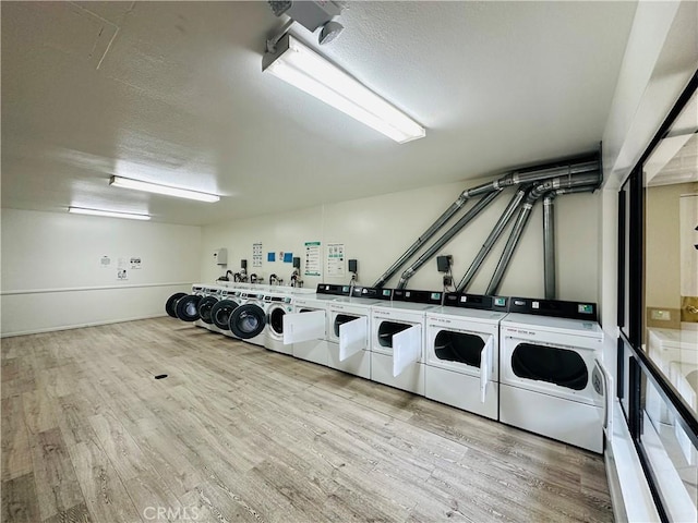 common laundry area featuring a textured ceiling, wood finished floors, and separate washer and dryer