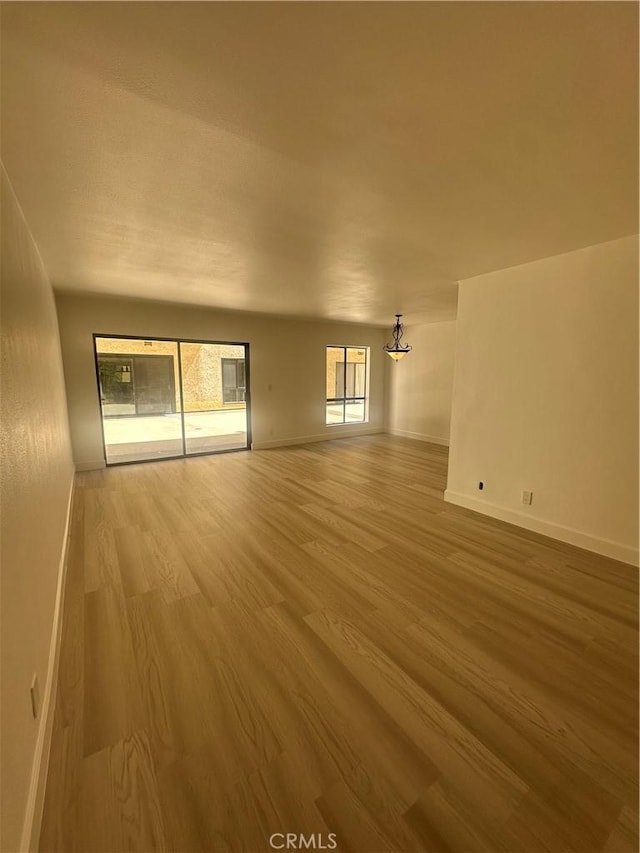 empty room with baseboards and wood finished floors