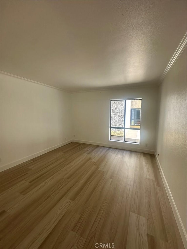 unfurnished room with wood-type flooring and ornamental molding