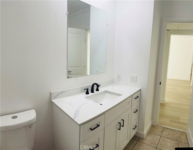 bathroom with tile patterned floors, toilet, vanity, and baseboards