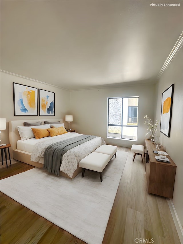 bedroom with light wood-style flooring and crown molding