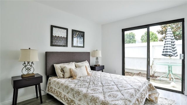 bedroom featuring access to outside, wood finished floors, and baseboards