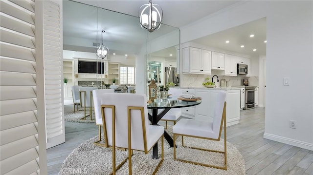 dining room featuring baseboards, light wood-type flooring, visible vents, and recessed lighting