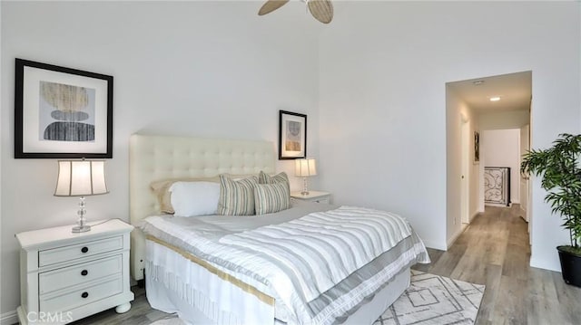 bedroom featuring baseboards, a ceiling fan, and light wood-style floors