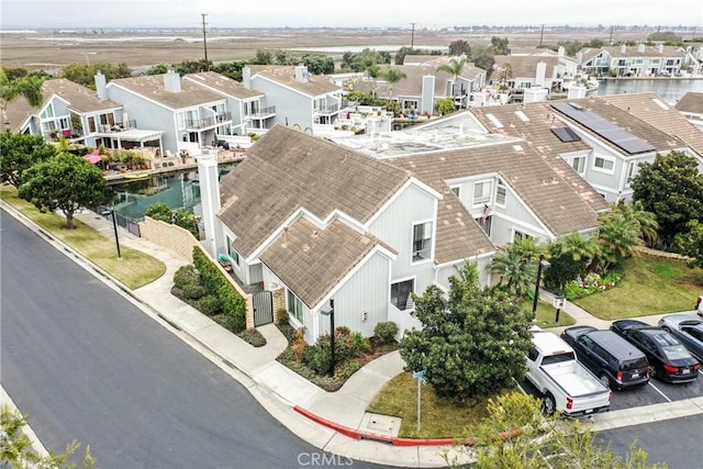 drone / aerial view with a residential view and a water view