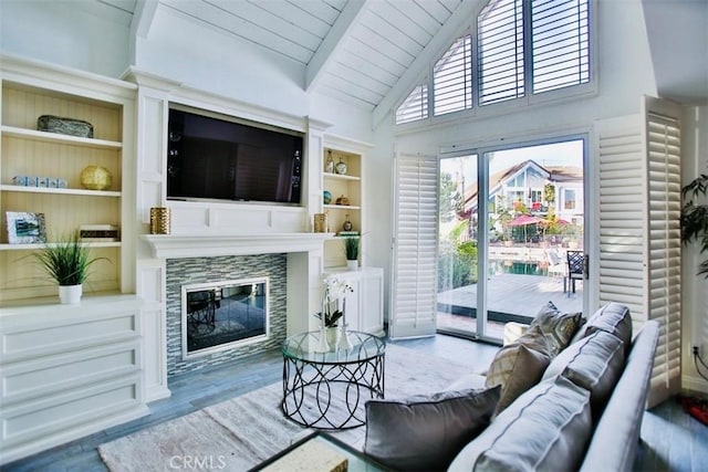 living area featuring built in features, a glass covered fireplace, wooden ceiling, beamed ceiling, and wood finished floors