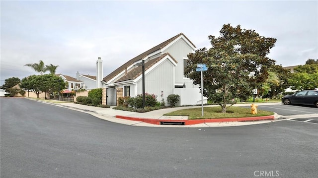 view of street with sidewalks, a gate, and curbs