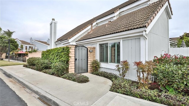 view of front of home featuring a tiled roof and fence