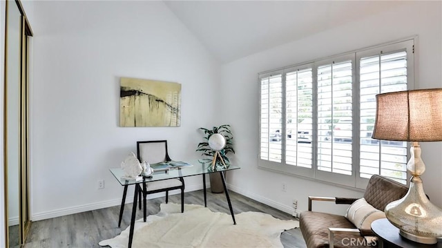 office area with plenty of natural light, vaulted ceiling, baseboards, and wood finished floors