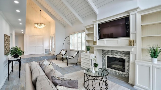 living room with light wood-style flooring, wood ceiling, visible vents, beam ceiling, and a tiled fireplace