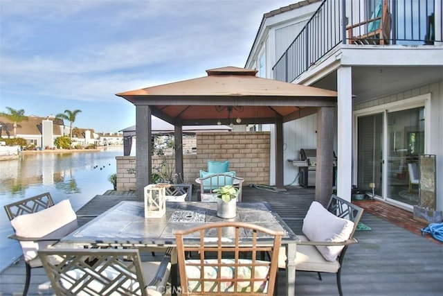 deck featuring a gazebo, outdoor dining space, area for grilling, and a water view