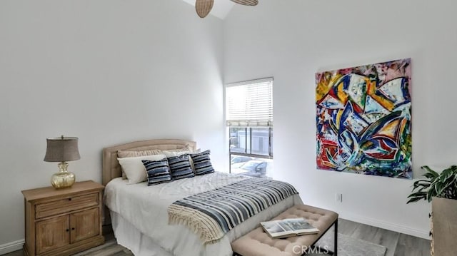 bedroom featuring a ceiling fan, baseboards, and wood finished floors