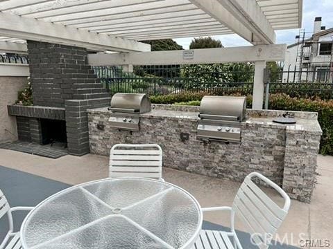 view of patio featuring exterior kitchen, a pergola, and grilling area