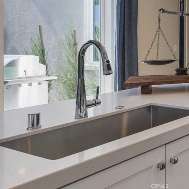 interior details featuring white cabinetry and sink