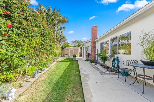 view of yard featuring a shed and a patio