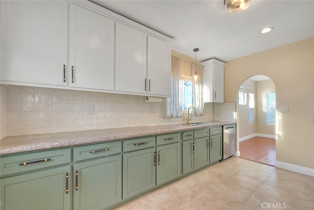 kitchen with pendant lighting, dishwasher, white cabinetry, tasteful backsplash, and sink