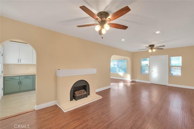 unfurnished living room with light wood-type flooring and ceiling fan