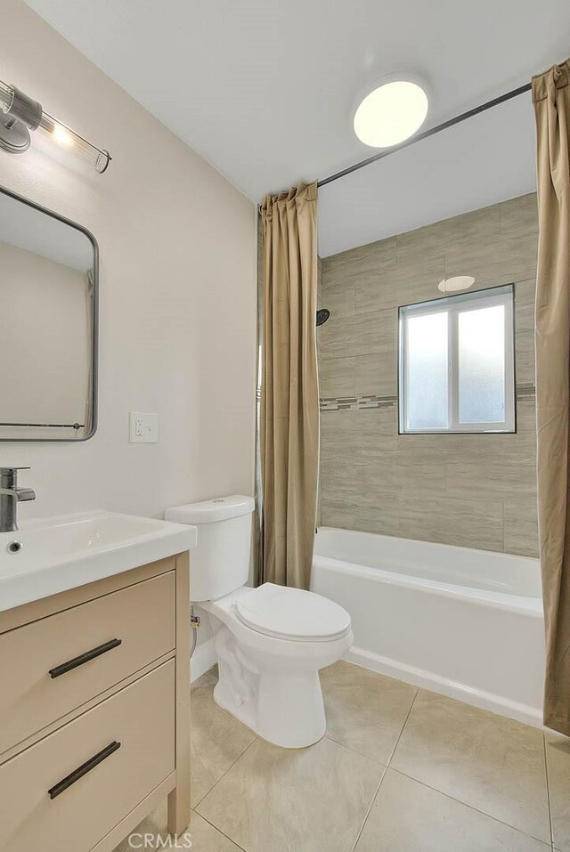 full bathroom featuring tile patterned floors, toilet, vanity, and shower / tub combo with curtain