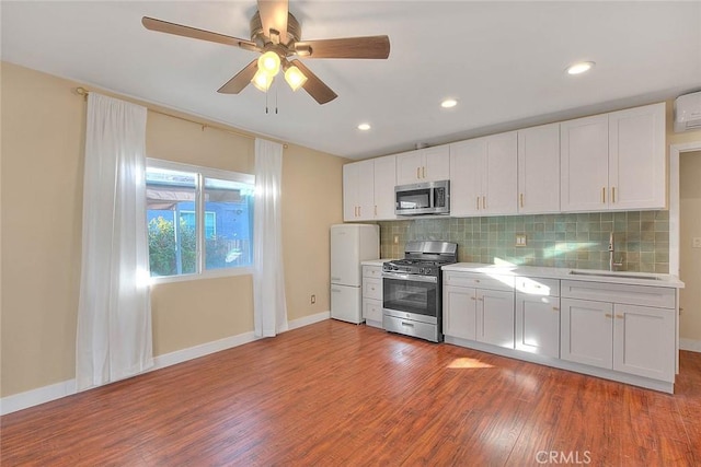 kitchen featuring stainless steel appliances, backsplash, white cabinetry, and sink