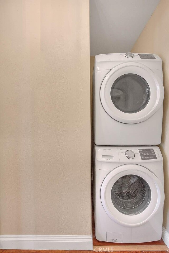 laundry area with stacked washing maching and dryer