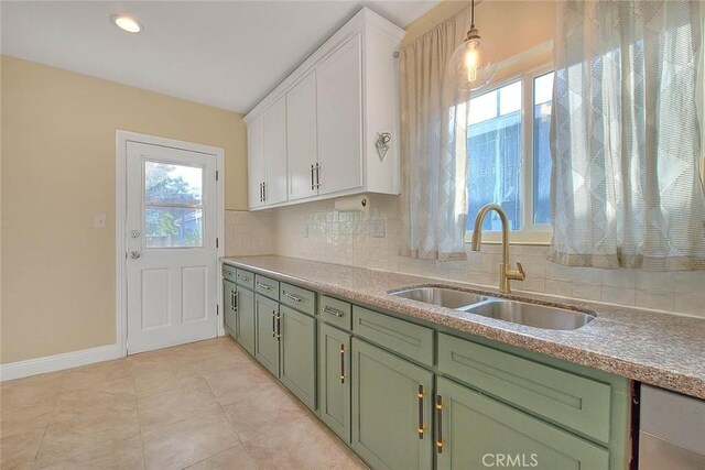 kitchen with hanging light fixtures, a healthy amount of sunlight, sink, and white cabinetry