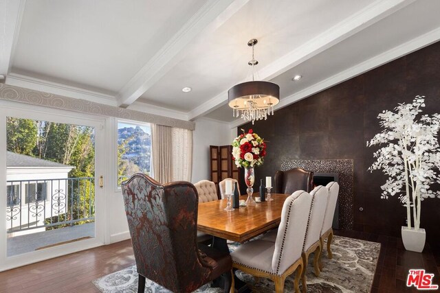 dining space featuring dark wood-type flooring, beamed ceiling, crown molding, and a notable chandelier