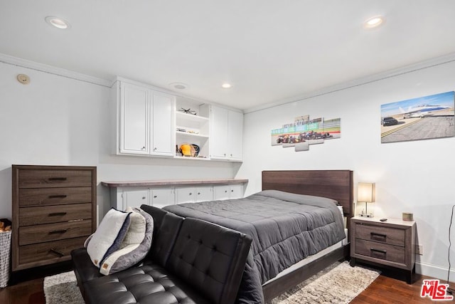 bedroom with dark hardwood / wood-style flooring and ornamental molding