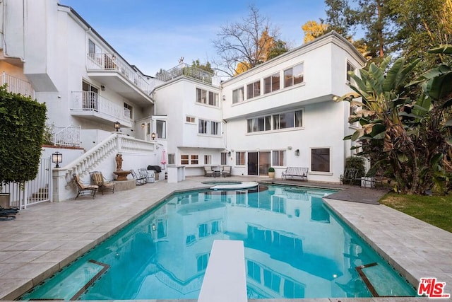 view of pool featuring a diving board, a patio area, and an in ground hot tub