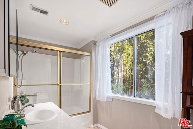 bathroom with shower / bath combination with glass door, ornamental molding, and sink