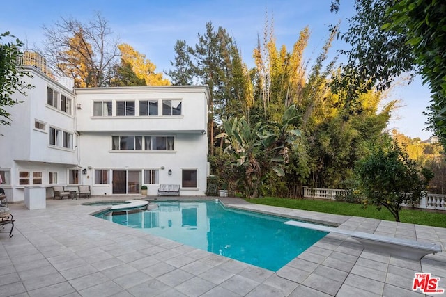 view of swimming pool with a diving board and a patio area