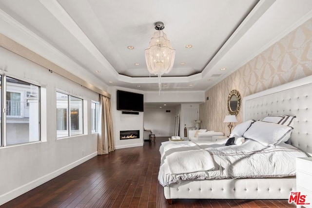 bedroom featuring dark hardwood / wood-style flooring, a tray ceiling, and a chandelier