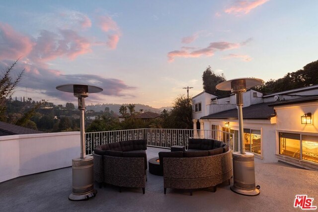 patio terrace at dusk featuring an outdoor living space