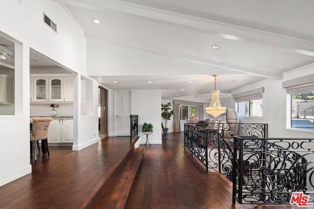 hallway with dark hardwood / wood-style floors and vaulted ceiling with beams