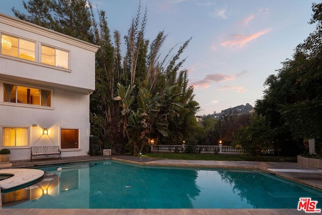 view of pool at dusk