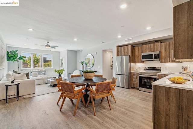 dining area with ceiling fan and light hardwood / wood-style floors