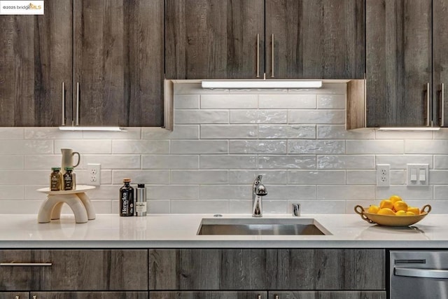 kitchen with decorative backsplash, dark brown cabinetry, and sink